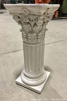 Full view of decorative Roman column plinth showing Corinthian capital and fluted shaft.