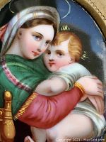 Close-up of hand-painted porcelain miniature depicting Virgin Mary holding Christ child with vivid coloration and fine detail.