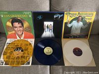 Three vinyl records visible with their colored vinyl LPs and album covers: Elvis Presley Gold Records Vol 4 (gold vinyl), Moody Blues Octave (blue vinyl), Peter Appleyard Presents (white vinyl).