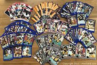 Photo of approximately 125 Hamilton Tiger-Cats trading cards spread in groups by card border color (red, yellow, blue, black) showing player images and action shots.