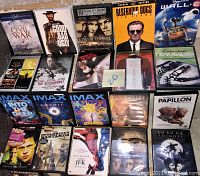 Photo showing all 22 DVDs laid out, including various movie titles and series, plus 6 digital press kits.