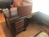 Image of L-shaped wooden office desk showing drawers and keyboard tray section.