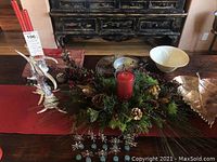 Lot displayed on a table with red linens and rustic background, including centerpiece, bowls, plates, leaf dish