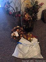 Artificial floral arrangements and loose flowers bag on carpeted floor