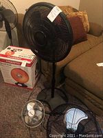 Image showing 3 fans: a tall black Galaxy floor fan with round base, a small metal tabletop fan, and a medium blue and black metal fan.
