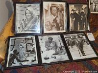Framed black and white movie and TV stills arranged in two rows on a surface.