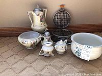 Set of five Royal Rochester hand painted china pieces arranged with a vintage waffle iron and a large English bowl on carpeted floor.