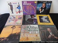 Nine vinyl record albums arranged in rows, showing full album covers to identify titles and artwork.