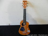 Front view of the Bugs Gear ukulele showing the full body and strings.