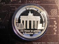 Obverse side of the silver token showing Brandenburg Gate with text 'Die Mauer ist gefallen 9. November 1989' commemorating the fall of the Berlin Wall.