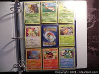 Photo of binder page displaying nine Pokémon cards including Kabutops, Yanma, Bellossom, Meowth, Grubbin, Corphish, Litten, and Poochyena