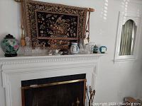 Wide view of mantel with urns, vases, glasses, and decorative pieces displayed on it.