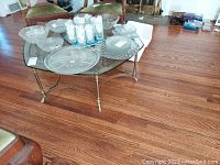 Glass top coffee table with various decorative glass plates on top, showing the entire table.