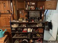 Wooden shelving unit loaded with assorted hardware bins, tools, adhesives, tapes and auto accessories