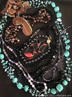 Overview of all 10 antique-style semi-precious stone necklaces and bracelets together on black background, showing variety of beads and stones.
