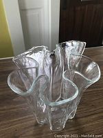 Full view of the clear art glass handkerchief vase showing the flowing edge design and textured surface.