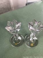 Pair of Waterford Marquis crystal candlesticks with original paper labels visible on the base. Clear detailed faceted flower-shaped candle holders.