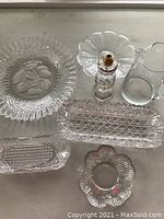 Overview of the 7 glass pieces laid out including pitcher, vegetable servers, dishes, perfume bottle, and the large etched platter.