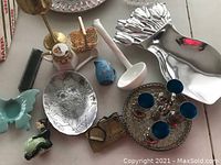 18 item decorative lot featuring brass, ceramics, glass, and aluminum pieces