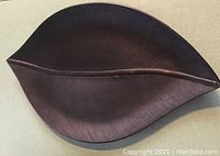 Close-up of a single bronze leaf shaped platter showing detailed texture and shape.