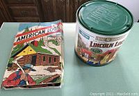 Two building construction toy sets side by side: vintage American Logs box on left and modern Lincoln Logs bucket on right.