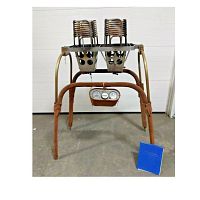 Front view of double burner assembly with burner coils, frame, instrument panel, and blue literature binder on floor