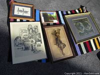 Five framed prints arranged on a colorful striped textile, showing size comparison and framing details.