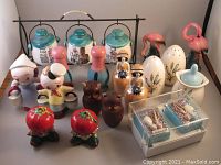 Front view of all nine sets of vintage salt and pepper shakers arranged together, showing various characters, colors, and materials.