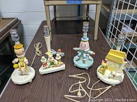 Four 1970s IRMI Nursery Originals children's lamps placed on floor showing characters and lamp fittings, no shades, cords visible