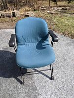 Front view showing blue padded seat and back, iron curved armrests, base visible