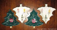 Four ceramic Christmas tree shaped snack bowls, 2 green with red ornament and 2 cream with painted ornaments, laid out together