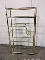 Front view of full etagere showing all six glass shelves and brass frame