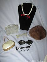 Wide view of all vintage women's fashion items including sunglasses, purses, mink hat, and Cadoro necklace.