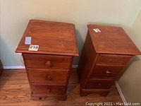Pair of wood end tables shown side by side. One has three drawers, the other one drawer and cabinet door. Both have round wooden knobs.