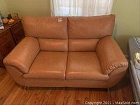 Front view of tan leather loveseat