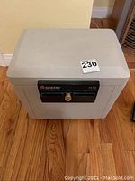 Closed Sentry 1170 safe on hardwood floor, showing front and top sides.