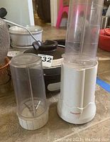 White and translucent plastic electric blender with blending jar and extra container jar; seller's lot number 232 visible