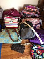 Multiple assorted bags displayed on floor and against wall showing colors and patterns