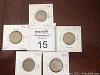 Five Canadian 25-cent silver quarters dated 1928, 1931, 1941, 1947, and 1949 displayed in cardboard holders.