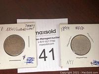 Two Newfoundland 20 cent coins in cardboard holders, showing dates 1881 and 1894