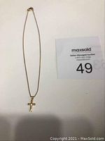 Full view of the 12 inch gold chain with attached cross pendant against a white background.
