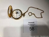 Full view of Birks pocket watch with chain and open cover showing dial with moonphase