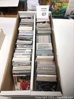 Two angled overhead shots of two white boxes filled with hockey cards stacked tightly.