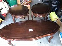 Top view of a wooden coffee table and two matching round end tables showing wear and scratches on surfaces.