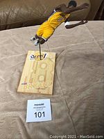 Full view of Kobe Bryant McFarlane figure mounted on wood base with Lakers logo and player name; figure in yellow uniform with number 8 jumping pose.