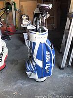 Full view of the Blue Light golf bag containing clubs in a garage setting.