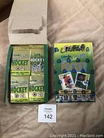 Opened box showing four unopened packs of 1992 O-Pee-Chee Premiere Hockey cards and a sleeve holding 28 additional unopened packs of the same hockey cards.