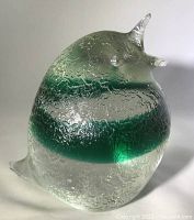 Close-up front angle of the large textured glass bird showing green color within clear glass and the textured surface.