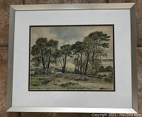 Complete framed watercolor painting showing the landscape scene with trees and open fields.