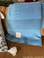 Blanket draped over couch showing full size, color and label area visible